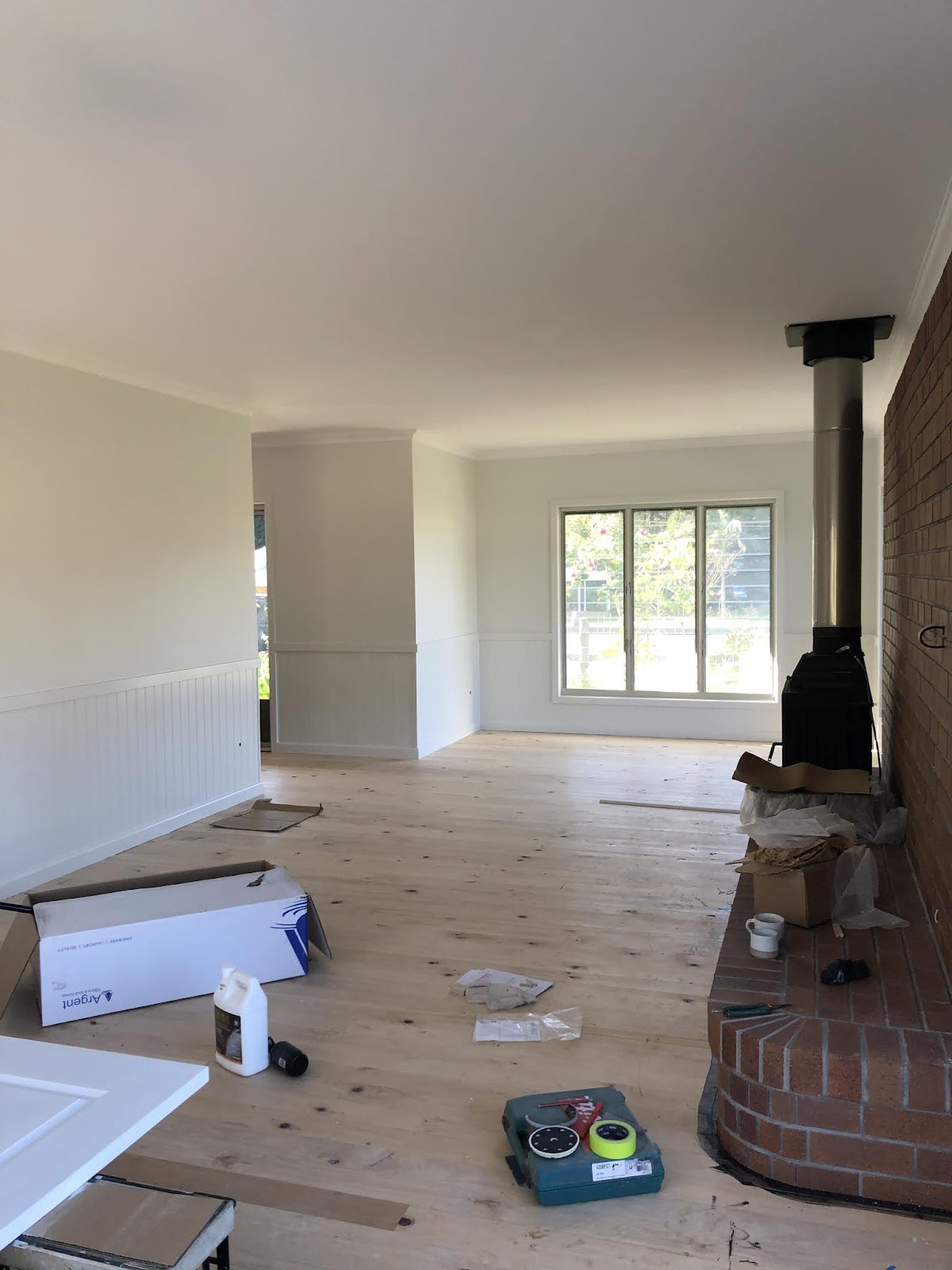 Renovated living room with a new timber floor and a wood heater